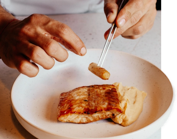 Chef adding final touch to his guests plate